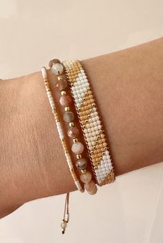 a woman's arm with two bracelets on it, one is gold and the other is white