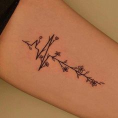 a woman's arm with an arrow and flowers tattoo on the left side of her leg