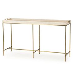 a white table with gold legs and a shelf on the top that has two compartments for storing items