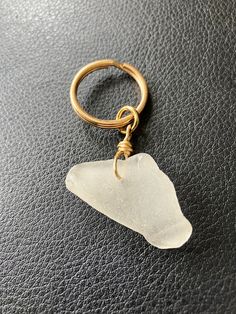 a sea glass keychain on a black leather surface