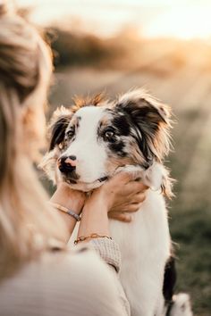 a woman holding a dog in her arms