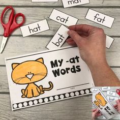 a hand holding a pair of scissors next to a cutout of a cat with the words my - at - words on it