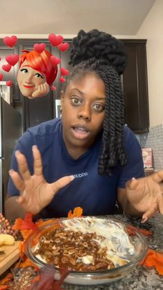 a woman sitting at a table with food in front of her and two faces behind her