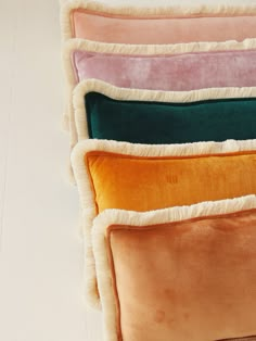 four different colored pillows stacked on top of each other