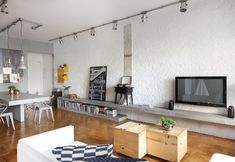 a living room filled with furniture and a flat screen tv on top of a wooden table