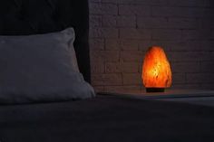 a lamp that is sitting on top of a bed next to pillows and pillow cases