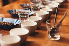 there are many cups and bowls lined up on the table with empty dishes in front of them