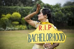 a woman holding a sign that says rip bachelorhood