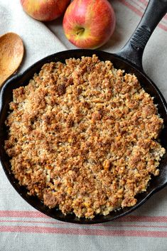 an apple pie in a cast iron skillet next to apples