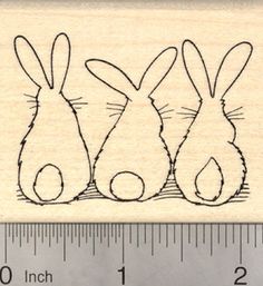 a rubber stamp with three bunnies on it and a ruler in front of it