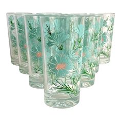 a set of six glass tumblers with flowers painted on the side and green stems