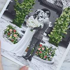 a bride and groom pose for a wedding photo in front of an arch with flowers