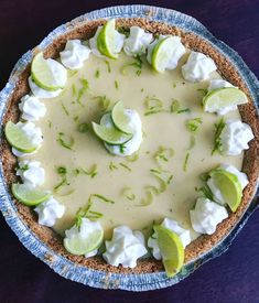 a pie with limes and marshmallows on top sitting on a table