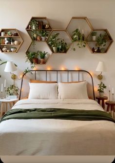 a bed with lots of plants on the headboard and shelves above it in a bedroom