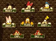 mickey and minnie mouse pin badges are on the wall in front of a black background