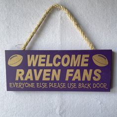 a sign that says welcome raven fans everyone else please use back door hanging on a wall