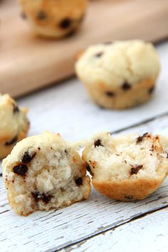 chocolate chip muffins sitting on top of a wooden table next to a cutting board