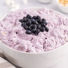 a bowl filled with blueberries and whipped cream