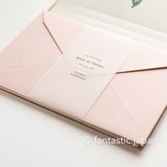 an open pink envelope with a card inside