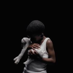 a woman holding a small white dog in her arms