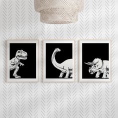 three black and white dinosaur prints on a wall