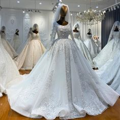 wedding gowns on display in a store with mannequins and chandeliers