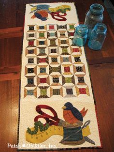 a quilted table runner with scissors on it