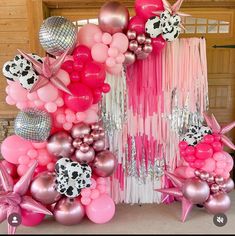 a bunch of balloons that are in the shape of animals and stars on a table