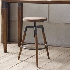 a wooden stool sitting in front of a table