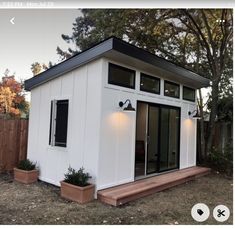 a small white house sitting in the middle of a yard