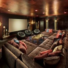 a living room filled with lots of couches and a projector screen in the corner