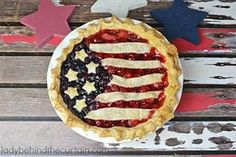 an american flag pie sitting on top of a wooden table next to red white and blue stars