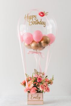 an air balloon with pink and gold balloons in it that says happy birthday on the front