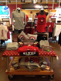 a display in a sports store with shirts and t - shirts on the table for sale