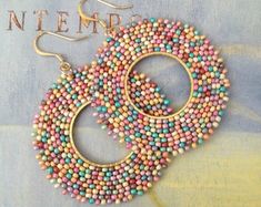 two pairs of beaded hoop earrings sitting on top of a magazine cover with the words in