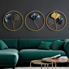 a living room with green couches and three circular metal wall art pieces on the wall