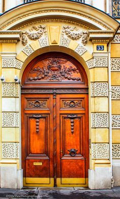 an old building with two wooden doors and ornate carvings on the front door, which is decorated in gold