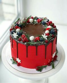 a red cake with chocolate frosting and berries