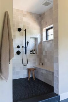 a bathroom with a bench and shower in it