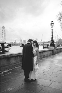 Couple standing by river Thames in London after their London elopement. French Chateau Wedding, Editorial Wedding Photography