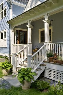 the front porch of a house with potted plants