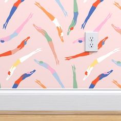 an electrical outlet in front of a pink wall with multicolored hand prints on it