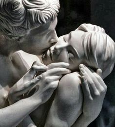 a statue of two people kissing each other with their hands on the face and shoulders