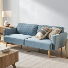 a blue couch sitting in a living room next to a table