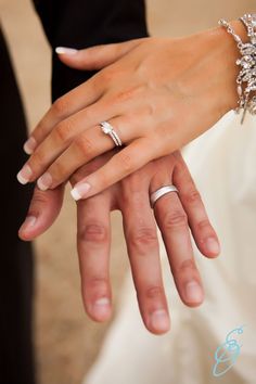 the bride and groom are holding each other's hands with wedding rings on their fingers