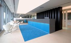 an office lobby with blue carpet and white chairs