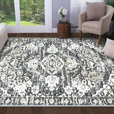 a living room with a large rug on the floor and two chairs in front of it