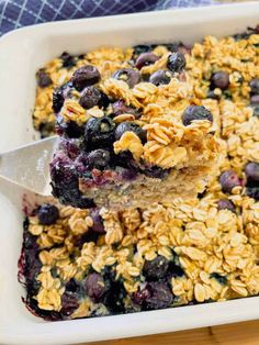 blueberry oatmeal breakfast casserole in a white dish with a spoon