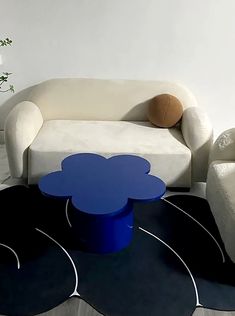 a living room with two couches and a flower shaped coffee table on the floor