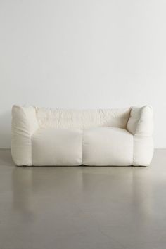 a white couch sitting on top of a cement floor